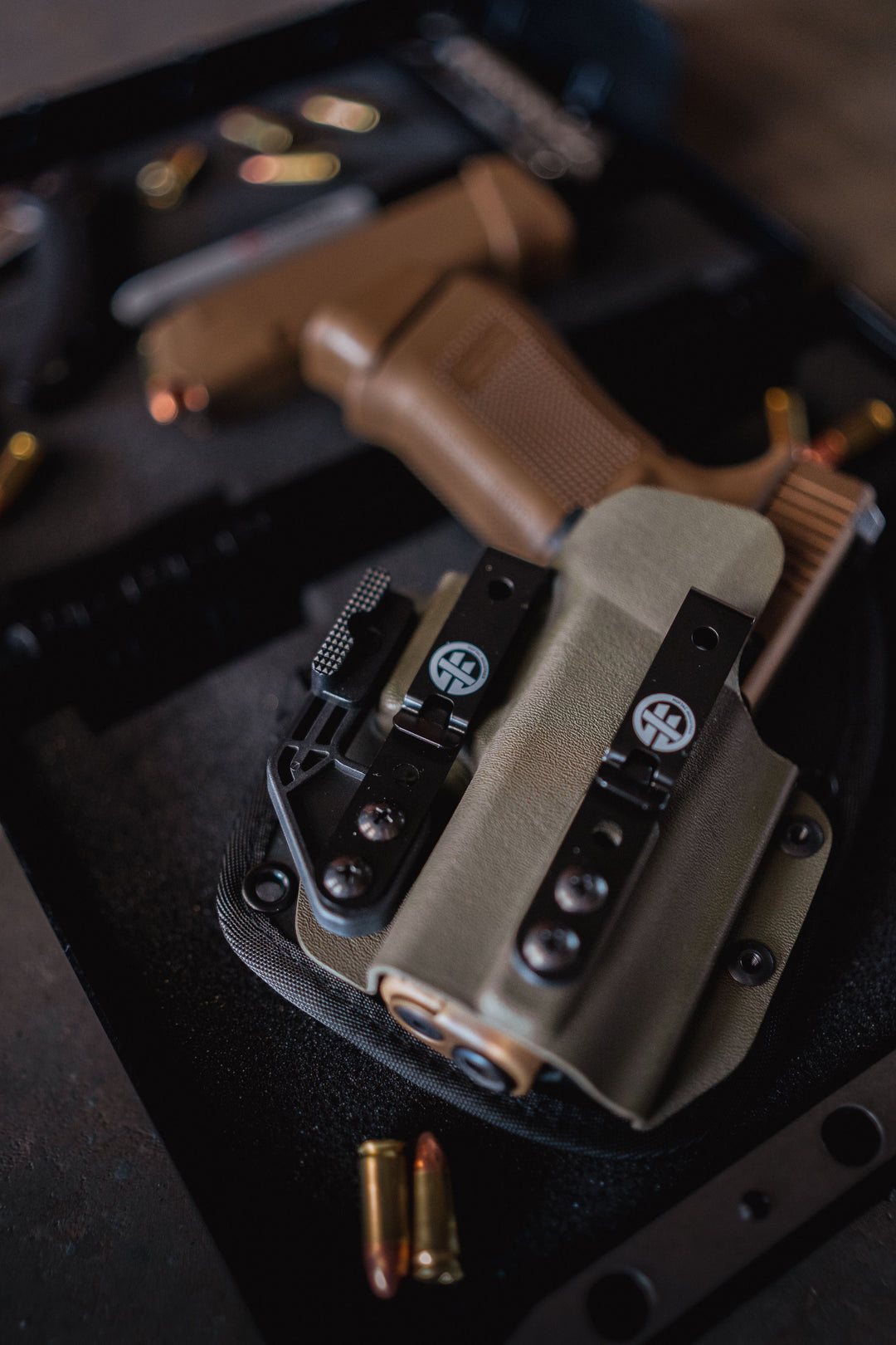 OMNICARRY IWB holster holding a Glock pistol inside a foam-lined case, featuring dual belt clips and adjustable retention, shown with loose 9mm ammunition nearby.